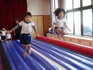 ４歳児がエアートランポリンでジャンプしている写真