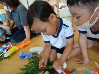 4歳児が笹の葉に飾りをつけている写真