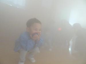 防火教室で幼児が煙体験をしている写真