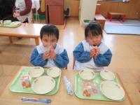 3歳児が給食のクレープを食べている写真