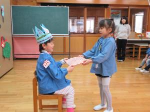 子どもが誕生日のプレゼントをもらっている写真