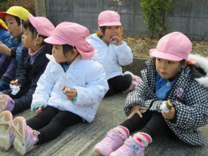 子どもたちがやきいもを食べている写真