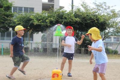 子どもたちが水遊びのおもちゃを使って遊んでいるところ