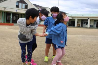 4人でなべなべそこぬけをしている写真