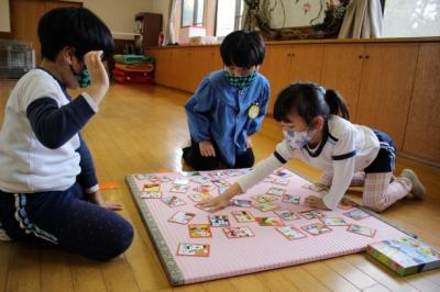 5歳児が3人組になり、読まれた札をとっている写真