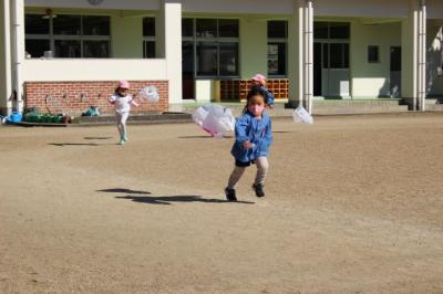 3歳児がナイロン袋の凧を持って走っている写真
