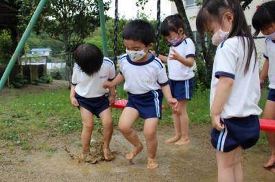 水たまりに裸足で入り、バシャバシャと遊んでいる写真