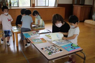 並んだ絵本を選び、読んでもらっている写真