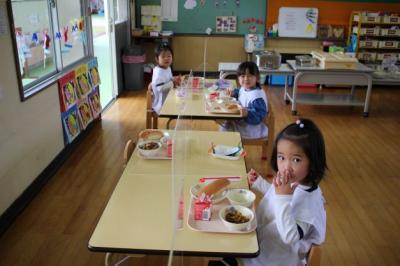 3人が給食を食べている写真の画像1