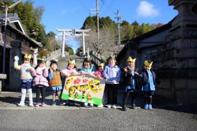 鳥居の前で絵馬をもって集合写真