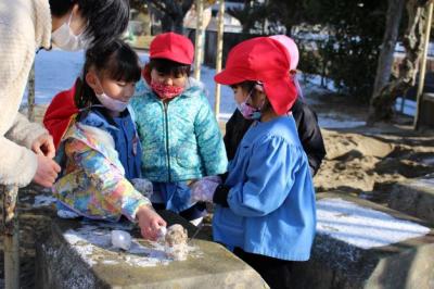 みんなで集めた雪を触っている写真