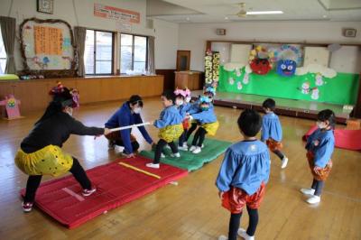 大人の鬼と子どもの鬼が綱引きをしている写真