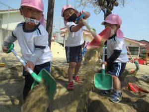 3歳児が砂場で遊んでいる様子