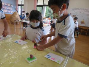 園児が芋スタンプで遊んでいる様子の写真