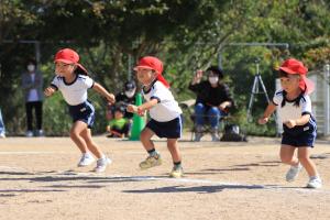 3歳児がかけっこでゴールに向かって走っているところ