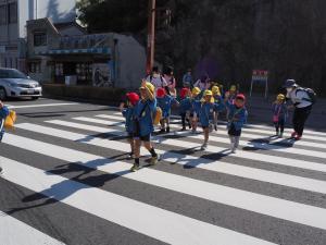 手を挙げて横断歩道を渡っているところ