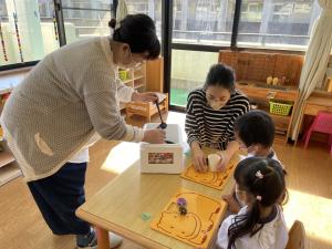 紙コップの中に溶かしたロウを入れてもらっているところ