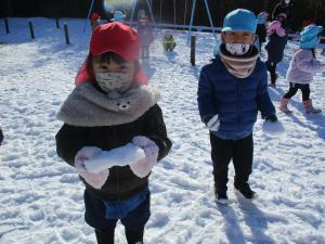 園児が雪遊びをする様子の写真