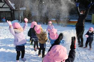 園児が雪遊びをする様子の写真