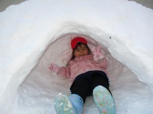 園児が雪遊びをする様子の写真