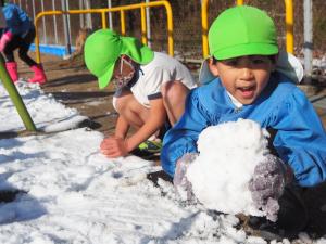 雪だるまを作ろうと雪を丸めているところ