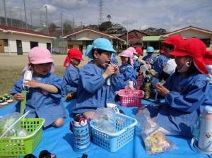 園庭でお菓子を食べている写真