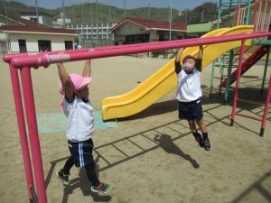 3歳児が雲梯にぶらさがっている写真