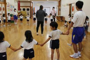 園児が中学生と遊んでいる様子の写真