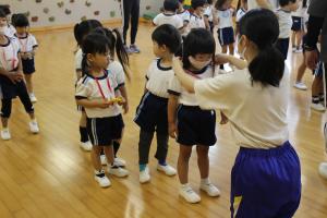 園児が中学生と遊んでいる様子の写真