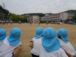 幼児が小学生の運動会の練習のダンスを見ている写真