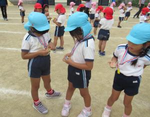 運動会の閉会式で幼児がメダルをもらっている写真