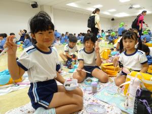 ５歳児が遠足でお弁当を食べている写真