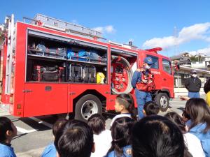 幼児が消防車についての話を聞いている写真