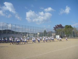 運動場で児童たちが駆け足をしている様子