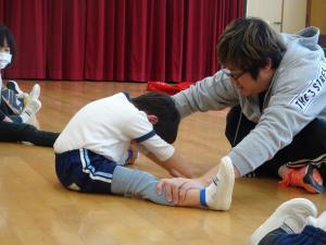 4歳児が坂口先生と一緒に柔軟体操をしている写真