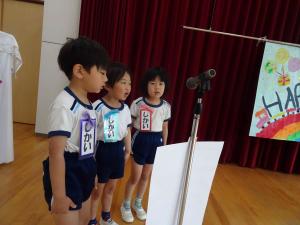 司会者がマイクの前に立っている写真