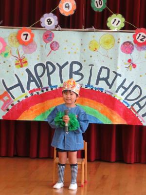 冠を被った子がマイクを持って立っている写真