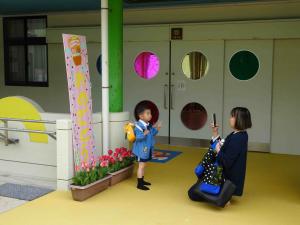 入園式の看板の前で写真を撮っている写真