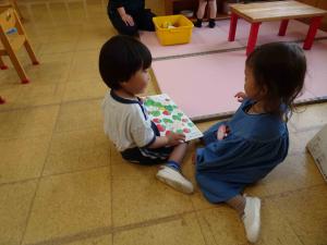 子ども2人が1冊の絵本を一緒に見ている写真