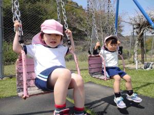 子ども２人がブランコに乗っている写真