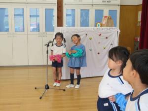 マイクの前に子どもが2人立っている写真