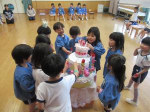 誕生会で大きなケーキが出てきて喜ぶ様子