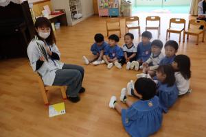 3歳児が絵本を読んでもらっているところ