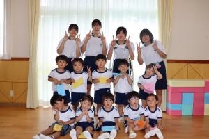3歳児と中学生が集合して写真をとっているところ