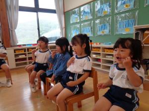 子ども達が歯ブラシをもって歯を磨いている写真
