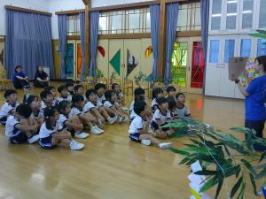 子ども達が座って紙芝居を見ている写真
