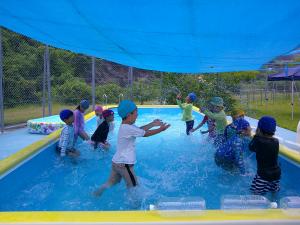 子ども達が向かい合わせで立ち、水のかけあいをしている写真