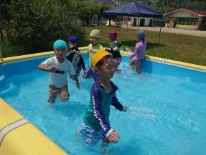 子ども達がプールの中で歩いている写真