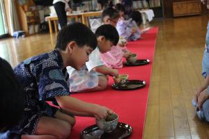 ４、５歳児がお茶を点てている写真