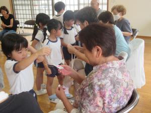 5歳児が敬老会でプレゼントを渡しているところ